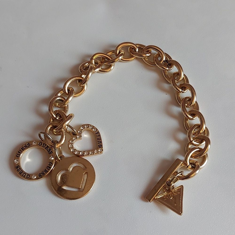 GUESS Gold Tone Heart Paved and  Logo Charms Toggle Clasp Bracelet